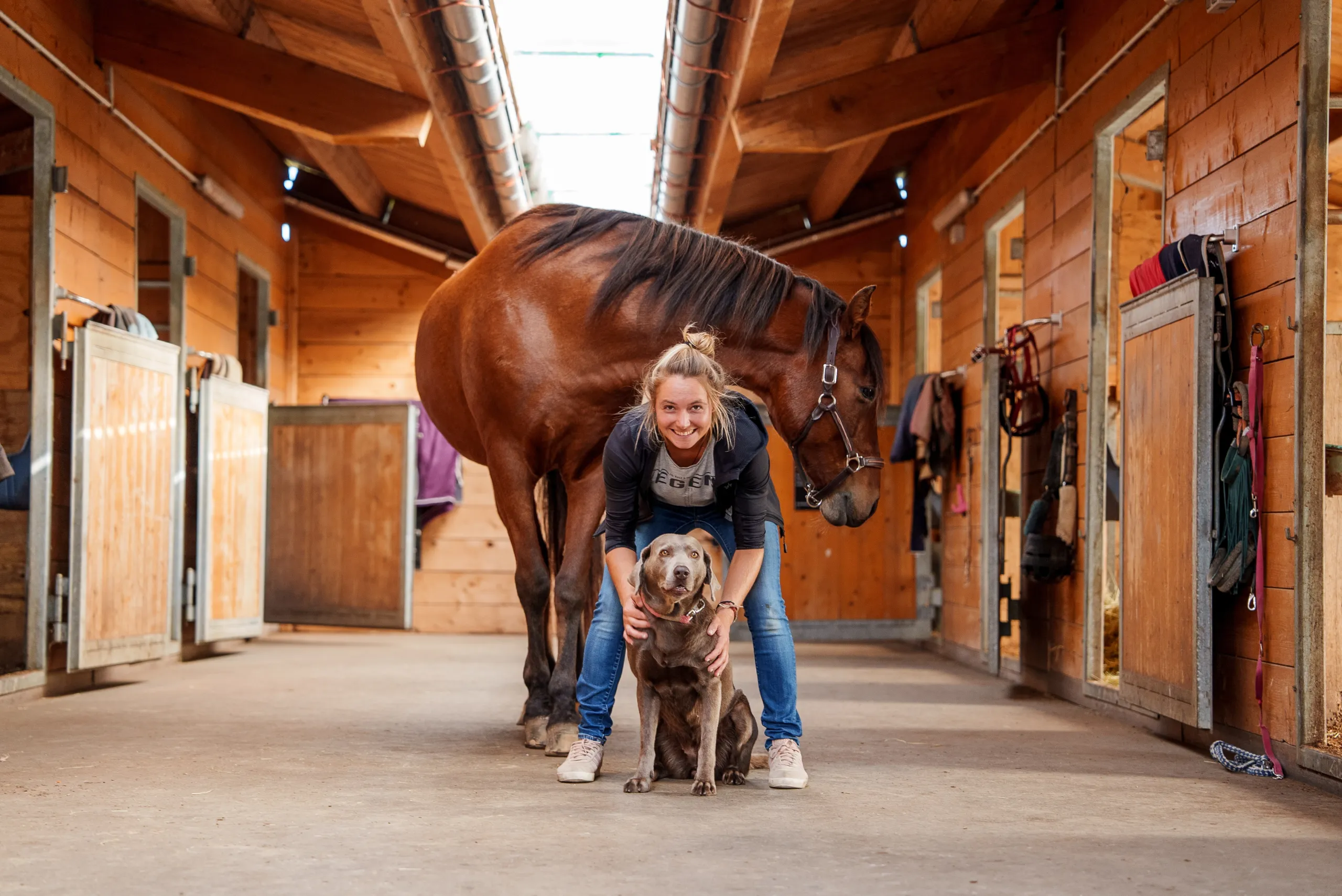 Tierärztin Jaqueline Göhle mit Hund und Pferd im Stall – Symbol für tierärztliche Betreuung mit Herz und Nähe zu Groß- und Kleintieren.